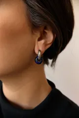 Aros de acero quirúrgico hipoalergénico con forma de argolla plateada y dije circular colgante de piedra natural color azul.