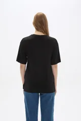 Remera negra de viscosa con textura acanalada, corte holgado y cuello redondo.