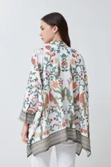 Camisa oversized con estampa floral en tonos naranja, verde y rojo sobre fondo blanco, con cuello clásico y cierre frontal con botones.