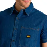 Camisa de manga corta de denim azul, con cuello camisero, cierre frontal con botones, bolsillo en el pecho izquierdo con logo CAT y dobladillo curvo.