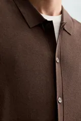 Camisa marrón de punto con viscosa, corte relaxed fit, cuello solapa, manga corta, rib a contraste y cierre frontal con botones.