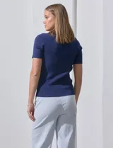 Buzo azul de tejido acanalado, con escote cuadrado y aplique de botones.