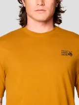 Camiseta de manga corta color mostaza con cuello redondo. Presenta un pequeño logo de Mountain Hardwear en el pecho izquierdo y un gráfico grande enmarcado en la espalda.