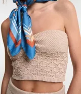 Blusa cropped color beige, confeccionada en tejido de punto texturizado, con escote sin breteles y fruncido en el busto.
