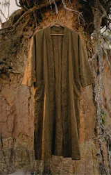 Kimono largo midi de manga amplia, color verde oliva, con cuello tipo solapa y bolsillos frontales. Presenta un calce relajado y fluido.