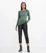 Suéter de punto color verde, con cuello barco, mangas largas y textura acanalada.