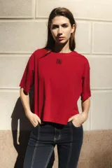 Remera negra de algodón con corte cuadrado, cuello redondo y logo bordado en color naranja.