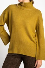 Polera color crema de tejido de punto, con cuello alto y mangas largas.