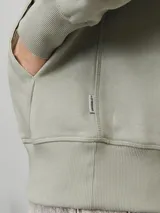 Canguro verde oliva de manga larga con capucha y fit regular. Tiene un bolsillo tipo canguro y estampado de goma con la palabra "Originals".