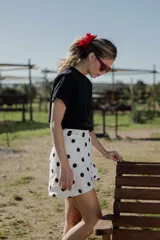 Minifalda pareo blanca con estampado de lunares negros y lazo lateral.