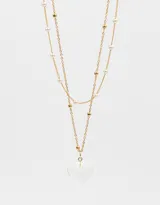 Collar corto dorado de doble cadena, una con perlas y otra con bolitas doradas. Dije de corazón transparente.