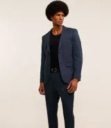 Pantalón de vestir azul marino, de corte recto, con bolsillos laterales y traseros. Se ajusta a la cintura con cinturón de cuero marrón.