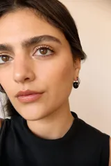 Aros de acero quirúrgico hipoalergénico con forma de argolla plateada y dije circular colgante de piedra natural color azul.