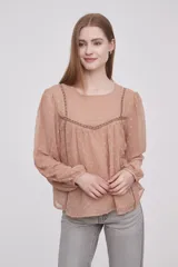 Blusa color beige oscuro con textura de lunares, cuello redondo y mangas largas abullonadas.