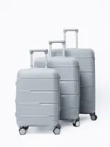 Valija rígida de viaje color gris con diseño de líneas horizontales. Cuenta con manija extensible, cuatro ruedas con giro de 360°, cierre con combinación y manija lateral.