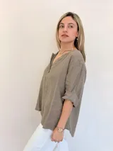 Blusa color gris topo, de lino, con escote en V y mangas 3/4 con puños arremangados.
