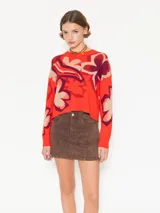Sweater de tejido frío confeccionado en jacquard tricolor con estampado de flores. De silueta amplia y relajada, con largo a la primera cadera y mangas largas. Su calce aporta una caída fluida y contemporánea.