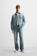 Pantalón de jean gris de corte recto, con cinco bolsillos, efecto lavado y cierre frontal con botones.