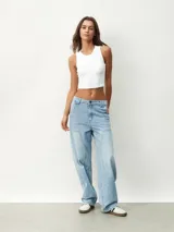 Pantalón de jean celeste, de corte ancho y tiro alto, con bolsillos laterales y traseros.