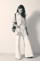 Pantalón de jean blanco de tiro alto, corte palazzo y denim con elastano.