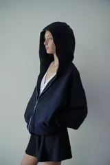 Campera negra con capucha, confeccionada en felpa de algodón extra suave, con cierre metálico de alpaca y bolsillos laterales. De corte oversize unisex.