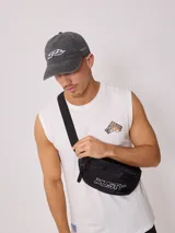 Riñonera negra marca Rusty con logo blanco estampado en el frente.