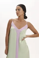 Vestido midi de satén color verde agua con panel central vertical color lila. Diseño suelto con breteles finos y escote en V.
