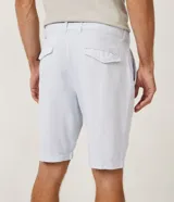 Bermuda de hombre en lino color gris claro, de corte recto, con textura discreta, bolsillos laterales y cierre frontal con botón y cremallera.