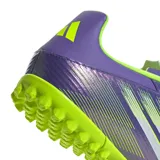 Championes de fútbol 5 Adidas F50 Club en color violeta con detalles en verde lima. Presentan una parte superior sintética con gráficos de velocidad, cierre de cordones y suela de goma con tapones pequeños optimizada para canchas de césped sintético.
