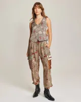 Pantalón cargo con estampado de motivos del oeste: sombreros de vaquero, cactus y vaqueros a caballo. Tiene dos bolsillos laterales y dos bolsillos grandes en las rodillas. La cintura es elástica.