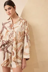 Short de lino color crudo con estampado de motivos marinos en tonos marrones.