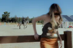 Top strapless negro confeccionado en gamuza con apliques geométricos de cuero en tonos beige y marrón. Presenta flecos en el ruedo.