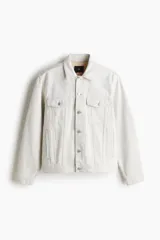 Campera de denim color crudo, de corte recto, con cuello clásico, cierre frontal con botones metálicos, bolsillos con solapa en el pecho y bolsillos laterales.