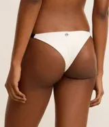 Bikini de microfibra texturizada color blanco, con corpiño triangular y bombacha colaless con laterales contrastantes y adornos de resina.