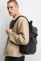 Mochila negra con acabado engomado, solapa y hebilla de liberación rápida. Tiene un bolsillo frontal con cierre imantado, asa de mano, dos asas de hombro ajustables, parte posterior acolchada y banda de sujeción para equipaje. El interior cuenta con un bolsillo con cierre y un compartimento para dispositivos electrónicos de hasta 13 pulgadas.