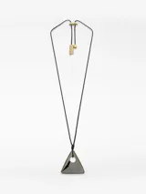 Collar con cordón negro largo y regulable, con un dije triangular de acabado brillante, posiblemente esmaltado o lacado, con un borde dorado y un orificio circular central. El cierre del cordón es ajustable mediante una pieza metálica dorada con terminales logotipados.
