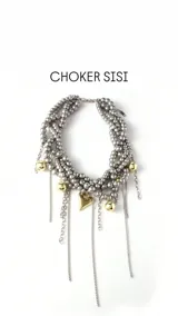 Gargantilla tipo choker de múltiples hilos de cuentas plateadas con colgantes de cadenas plateadas, cuentas doradas y un dije de corazón dorado.