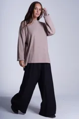 Sweater color beige de tejido de punto acanalado, con cuello redondo y mangas largas. Tiene corte holgado y aberturas laterales en el ruedo.