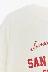Sudadera azul marino de cuello redondo y manga larga con estampado frontal que dice "New South Wales Sydney 1985 Bondi Beach" en color blanco.