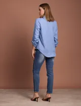 Blusa celeste con escote en V y mangas 3/4 regulables con presilla y botón.