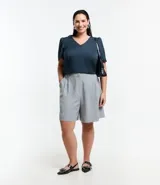Blusa de crepé color azul petróleo, con escote en V y mangas cortas abullonadas.