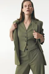 Blazer verde oliva de Zara Woman Collection, con cuello solapa, manga larga, bolsillos de vivo con solapa y cierre frontal con botones.