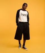 Remera masculina de algodón color blanco con mangas raglán negras, cuello redondo y estampa frontal de un gato con lettering "Chaos".