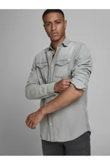 Camisa de denim gris de manga larga, con cuello clásico, cierre frontal con botones a presión y dos bolsillos con solapa abotonada en el pecho.