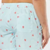 Short de baño celeste con rayas verticales blancas y estampado de pulpos rojos.