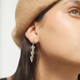 Pendientes largos plateados, tipo colgante, compuestos por tres corazones tridimensionales apilados por par.