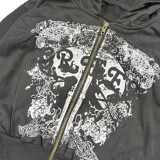 Campera negra con capucha y cierre frontal, con estampado de calavera y letras en blanco.