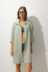 Vestido camisero a rayas verticales verdes y blancas, con cuello clásico, mangas 3/4 y cierre con botones.