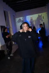 Canguro negro oversize con capucha y bolsillos laterales. Presenta un diseño estampado en gris plata con motivos esotéricos: estrellas, constelaciones y un unicornio alado.