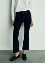 Pantalón de jean azul oscuro, de tiro alto, corte crop y acampanado. Cuenta con cierre de cremallera y botón, trabillas, cinco bolsillos y tejido elástico.